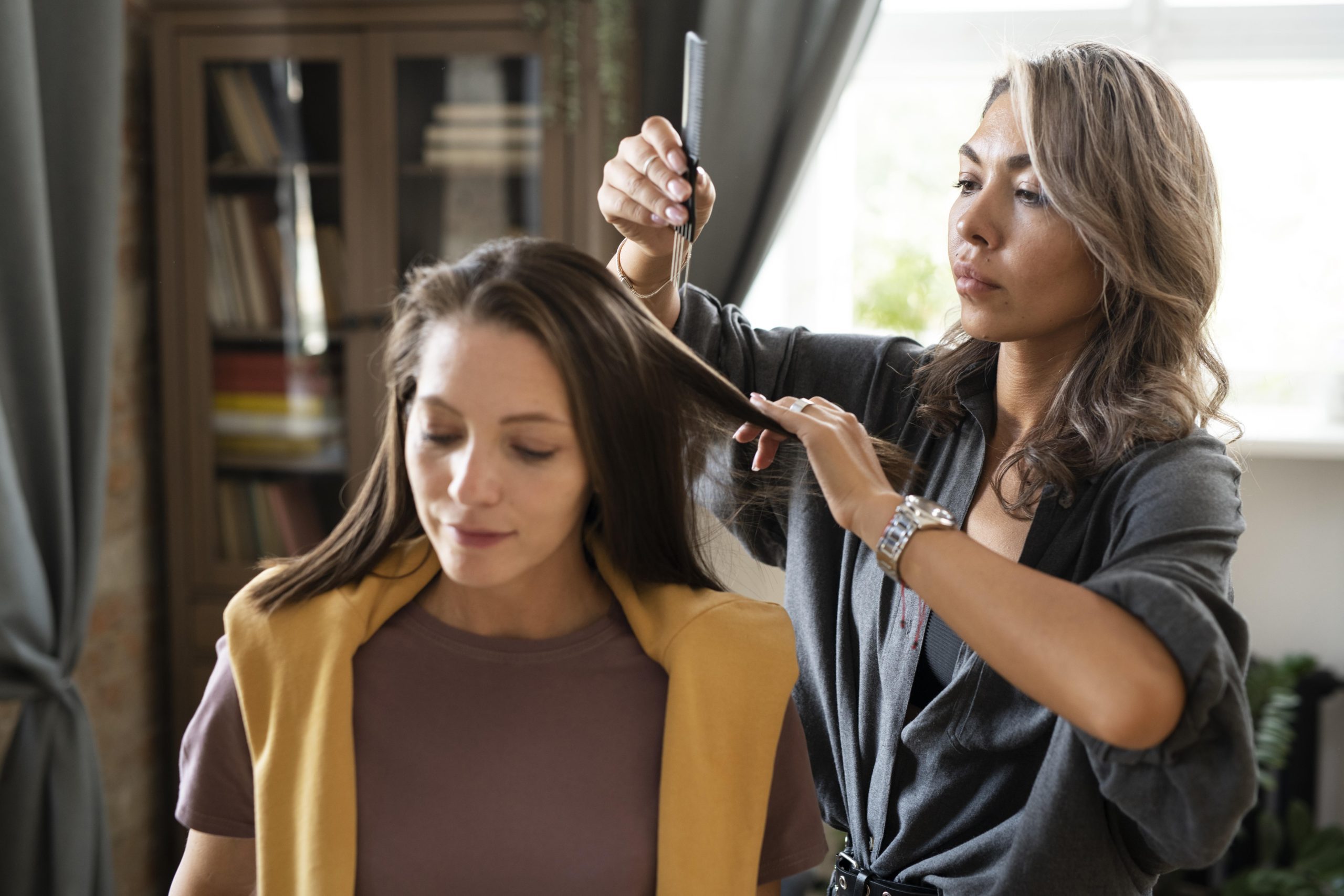 Focused hairstylist sectioning a client's hair with a comb, illustrating the demanding daily work behind the chair that can lead to stylist burnout in Sandy Springs salon suites.